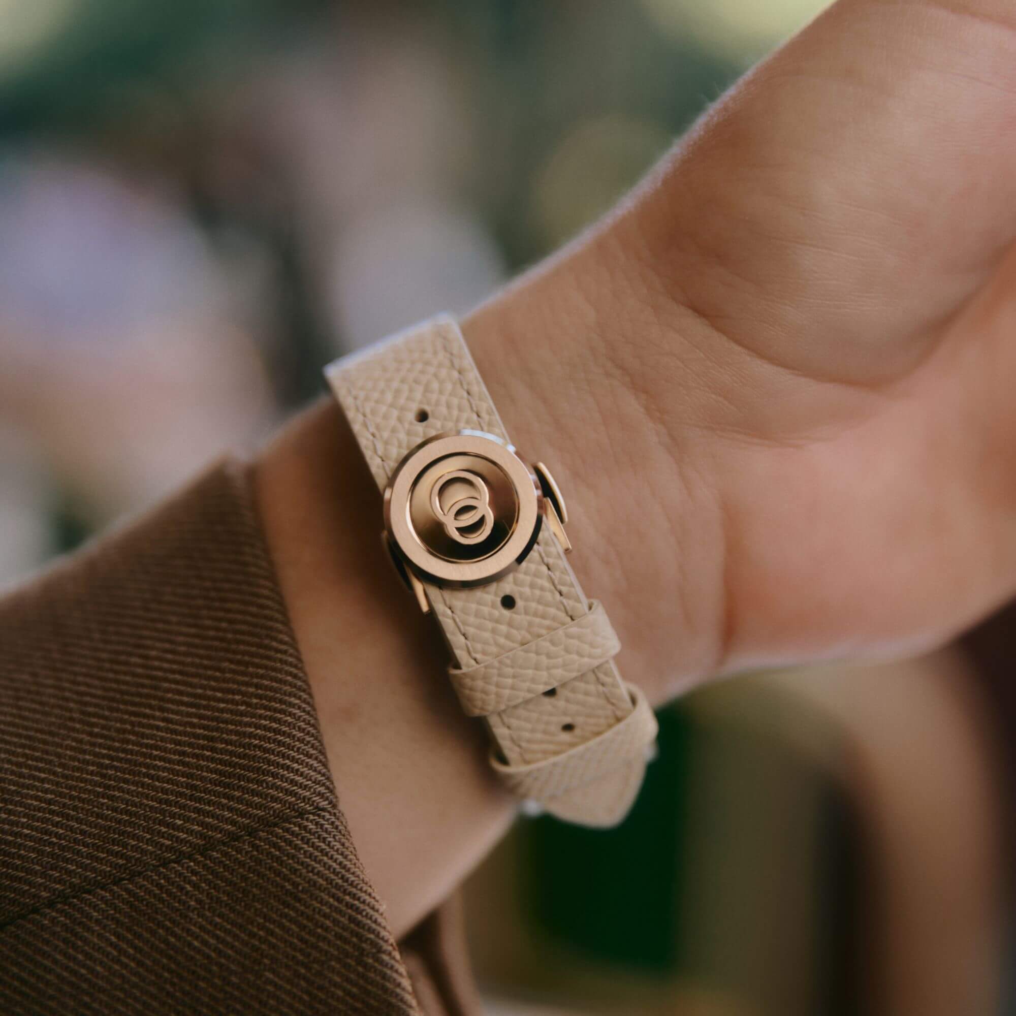 bracelet de montre grainé couleur crème avec zoom sur la boucle déployante en or rose