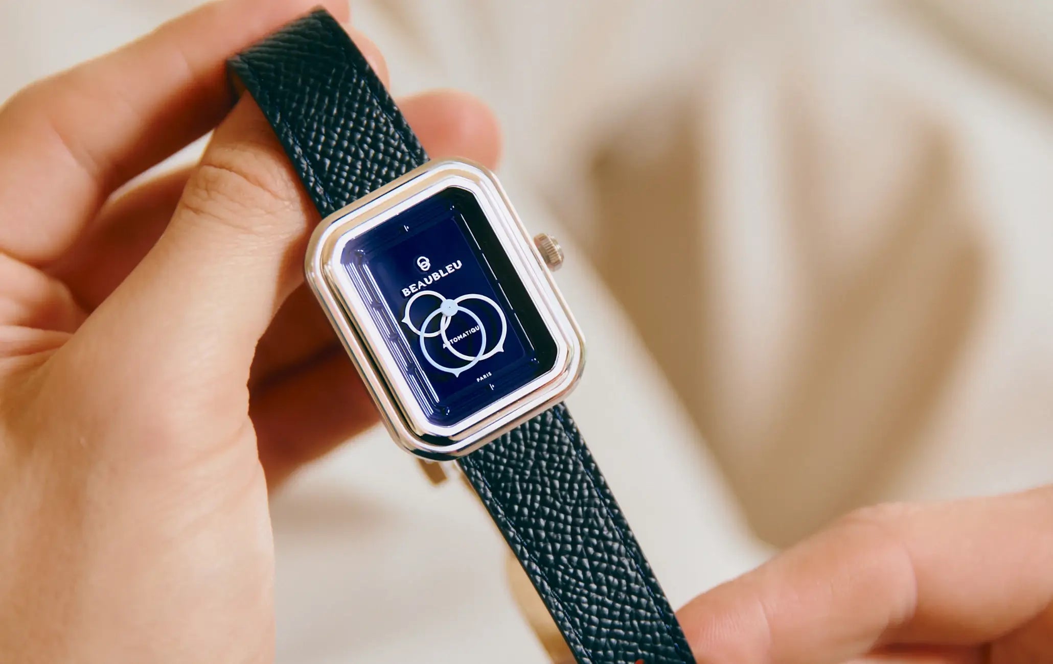 Montre automatique Ecce Figura Smalt tenue entre deux mains, cadran visible en gros plan