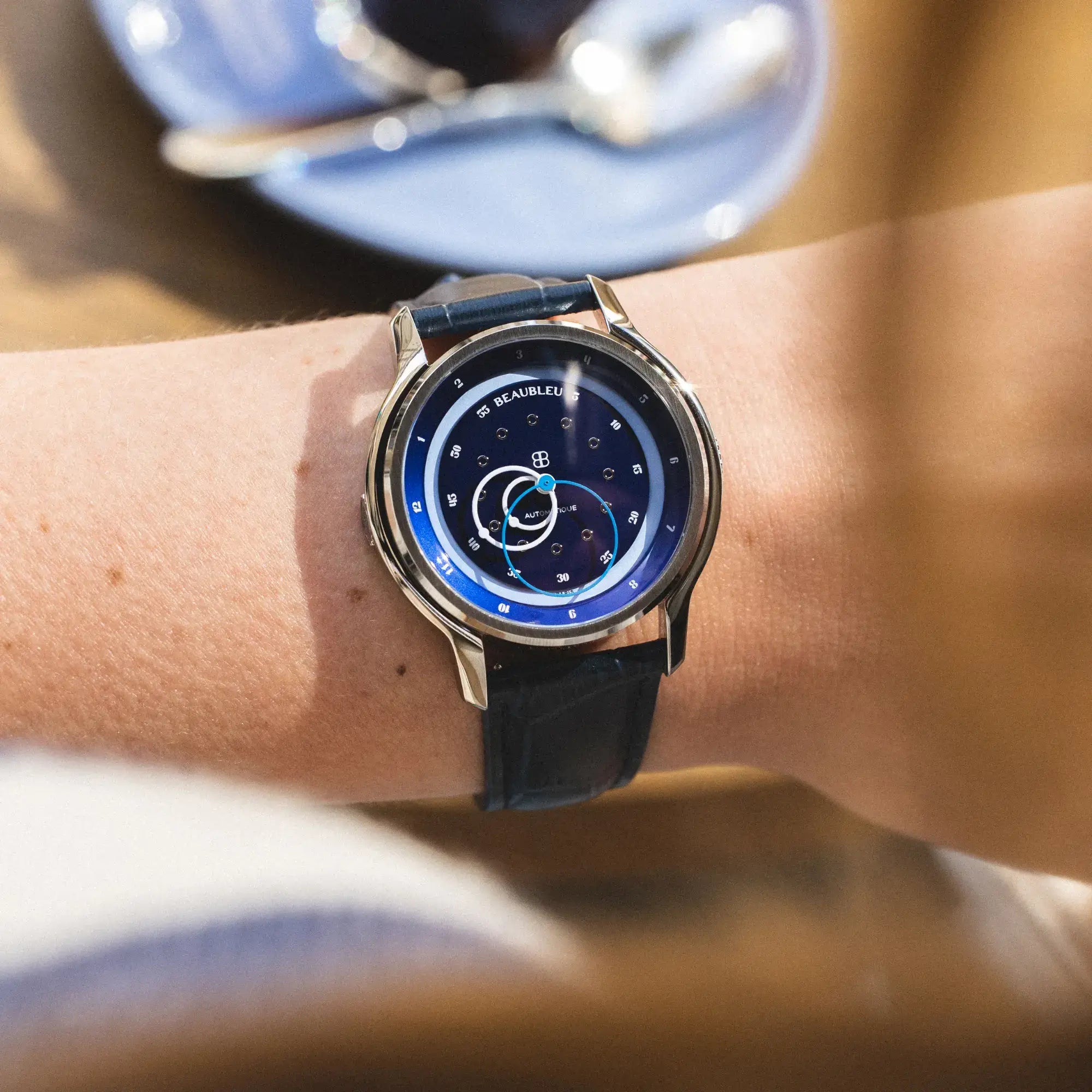 Montre GMT Bleu avec un bracelet en cuir bleu portée au poignet d'une femme