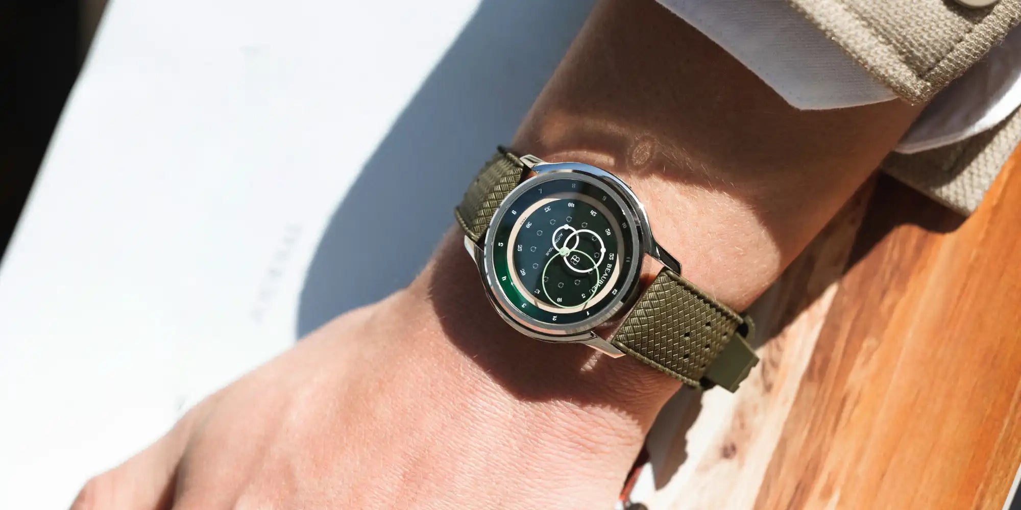 Montre GMT Verte avec un bracelet Tropic khaki portée au poignet d'un homme