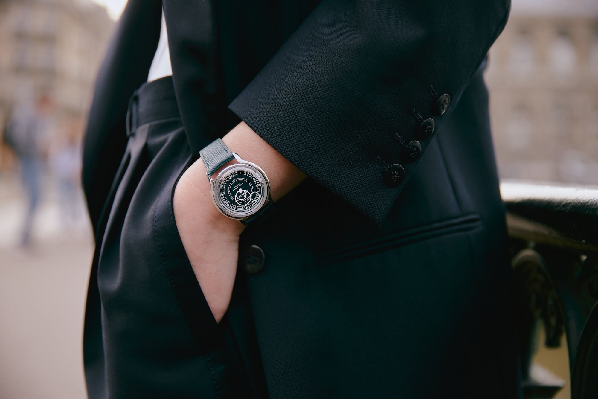 Poignet féminin portant une montre automatique au cadran vert
