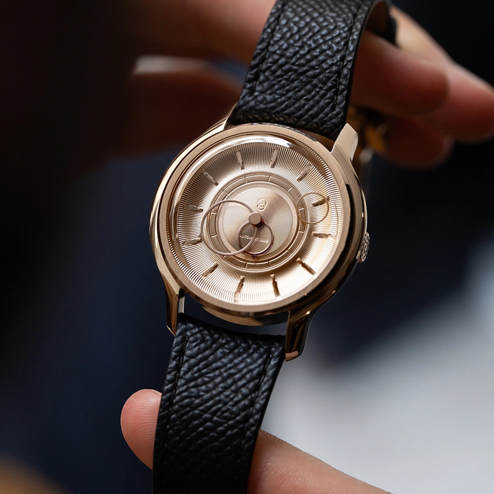 Montre La Pièce Or Rose de Beaubleu avec bracelet grainé noir tenue dans les mains