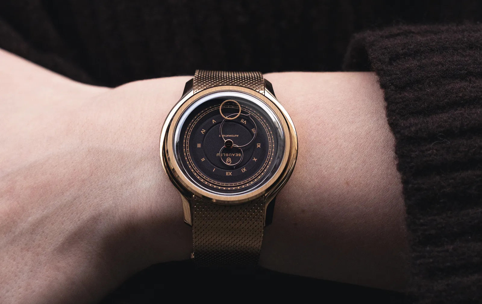 Gros plan sur la montre Moka de la collection La Pièce avec son bracelet en maille or rose