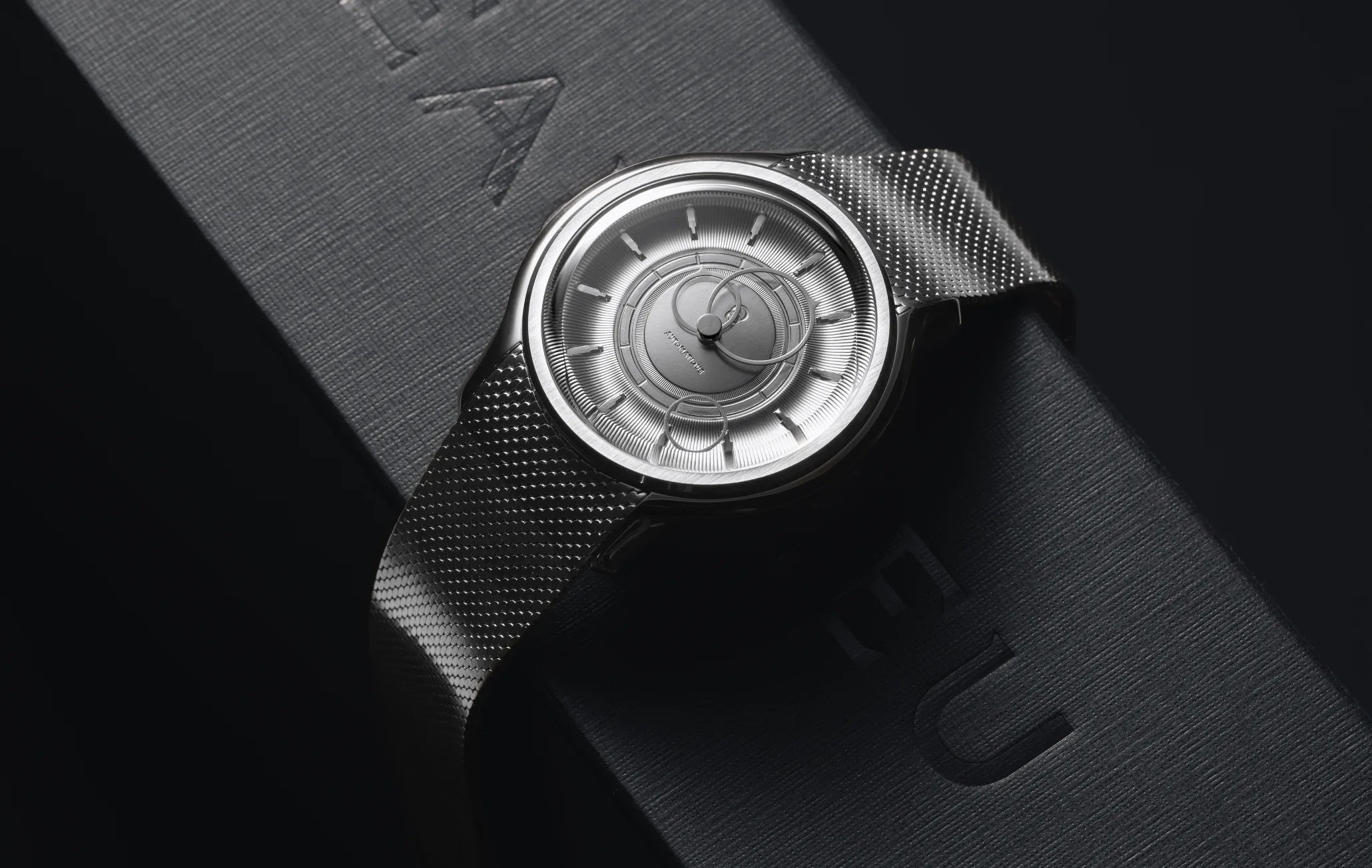 Montre La Pièce Argent de Beaubleu cadran acier posée sur une boite à montres noire