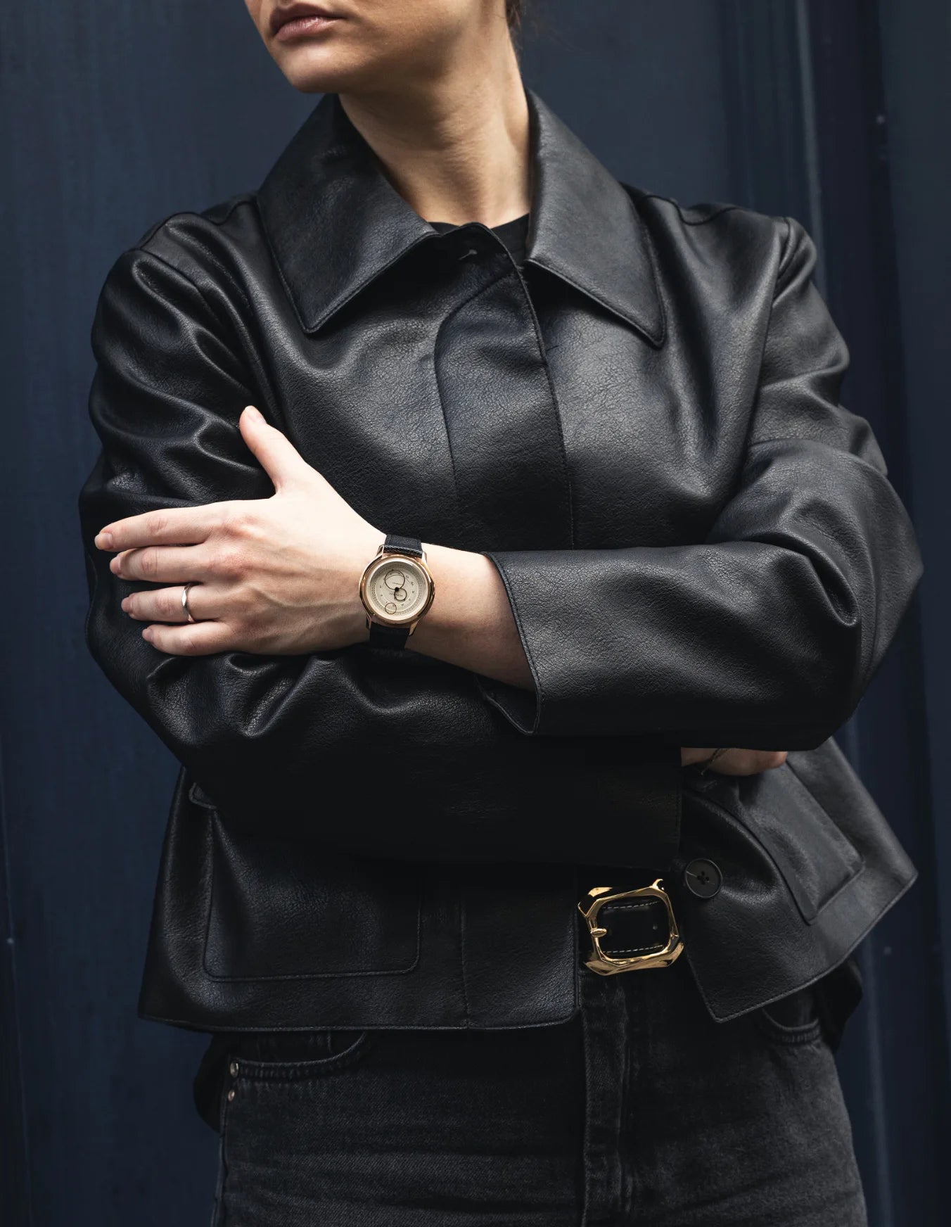 Montre Beaubleu La Pièce Champagne avec bracelet cuir grainé portée au poignet d'une femme avec une veste noire
