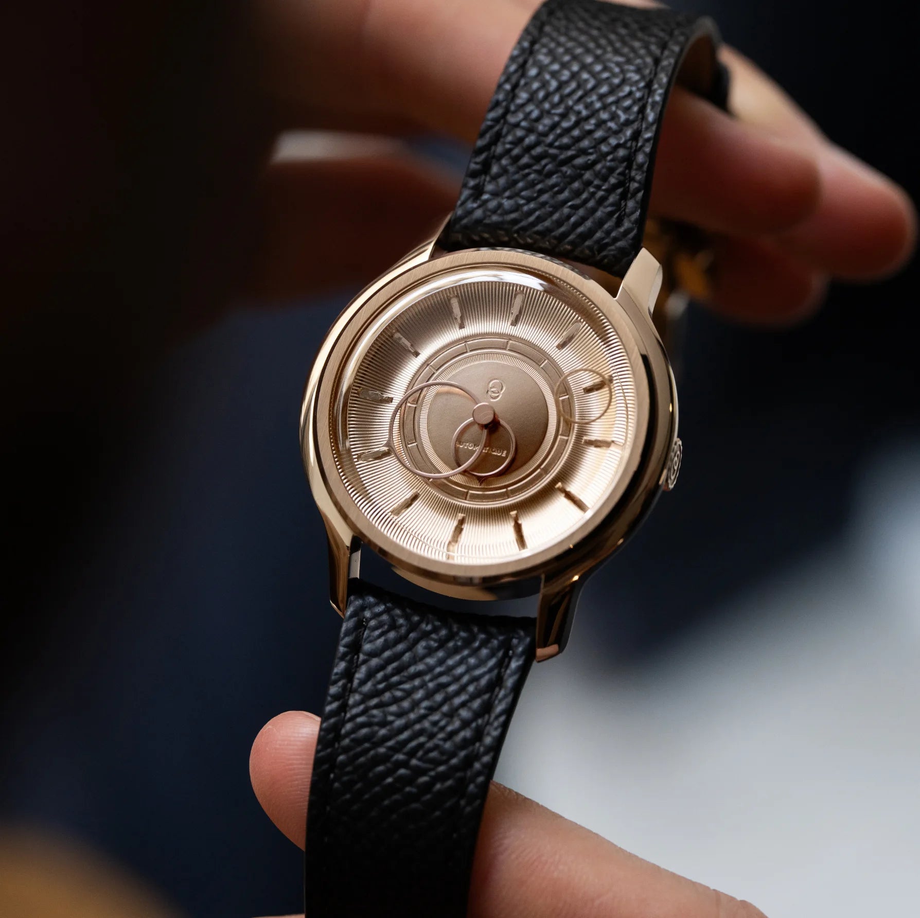 Montre La Pièce Or Rose de Beaubleu avec bracelet grainé noir tenue dans les mains